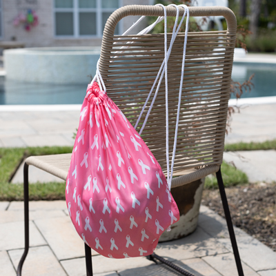 NAVIGATOR<sup>&reg;</sup> Pink Ribbon Drawstring Backpack—This handy lightweight tote has a cinch top closure and can be worn as a backpack. Measures 17.5" x 14.5"  and opens to 13.5" wide.